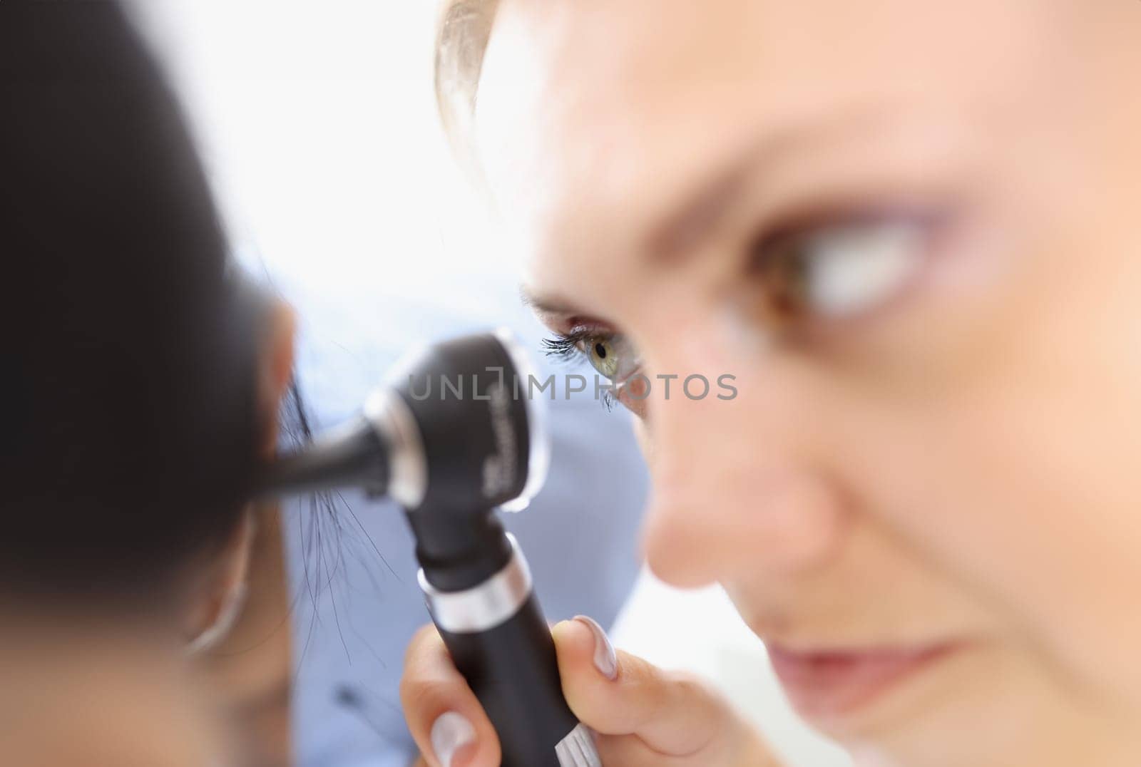 An otolaryngologist examines the patient ear closeup by kuprevich