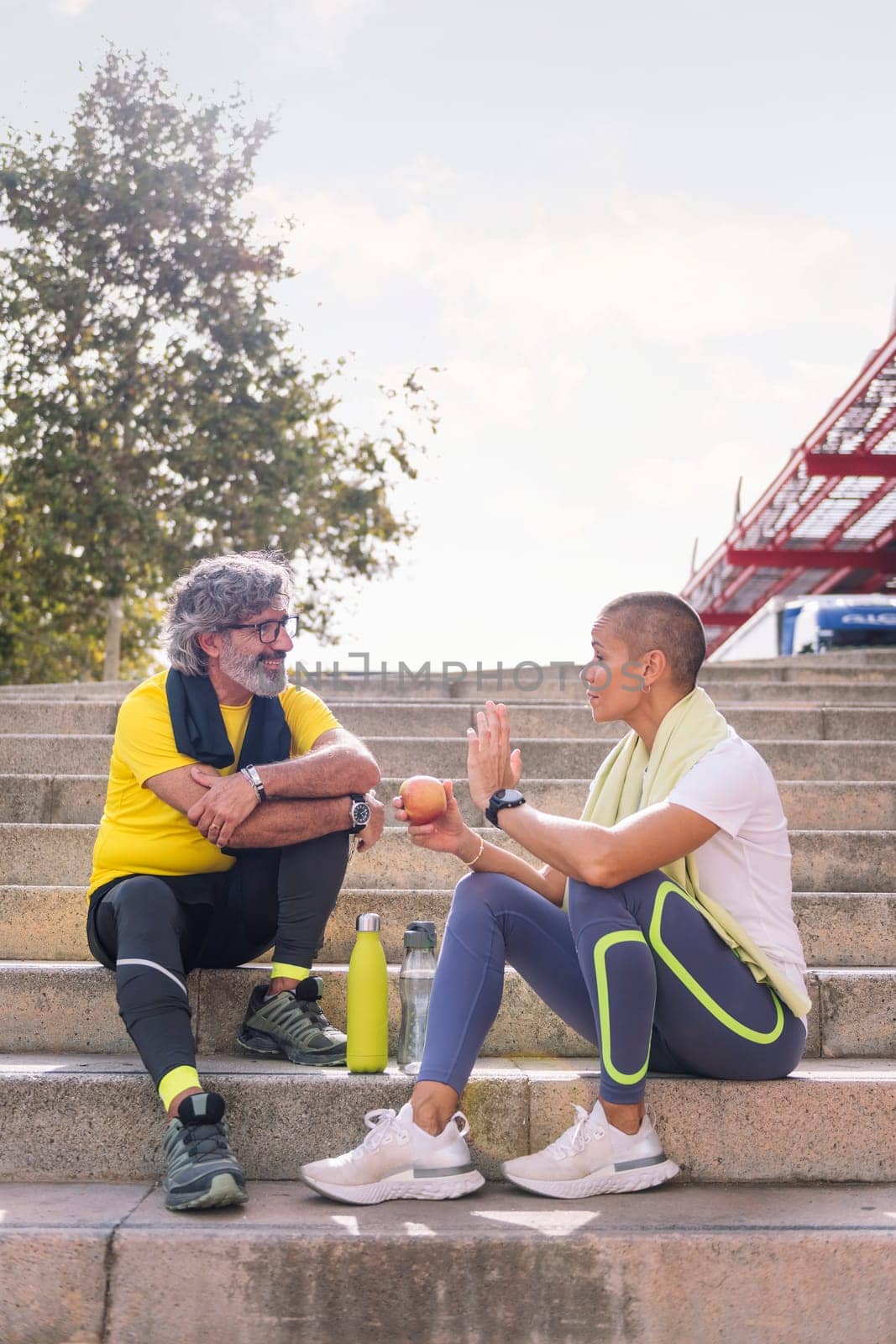 senior sports man rests chatting with his personal trainer after a hard workout, concept of healthy and active lifestyle in the middle age, copy space for text
