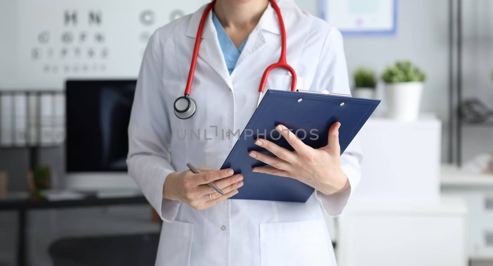 Woman doctor holding clipboard with documents in her hands closeup. Health insurance concept