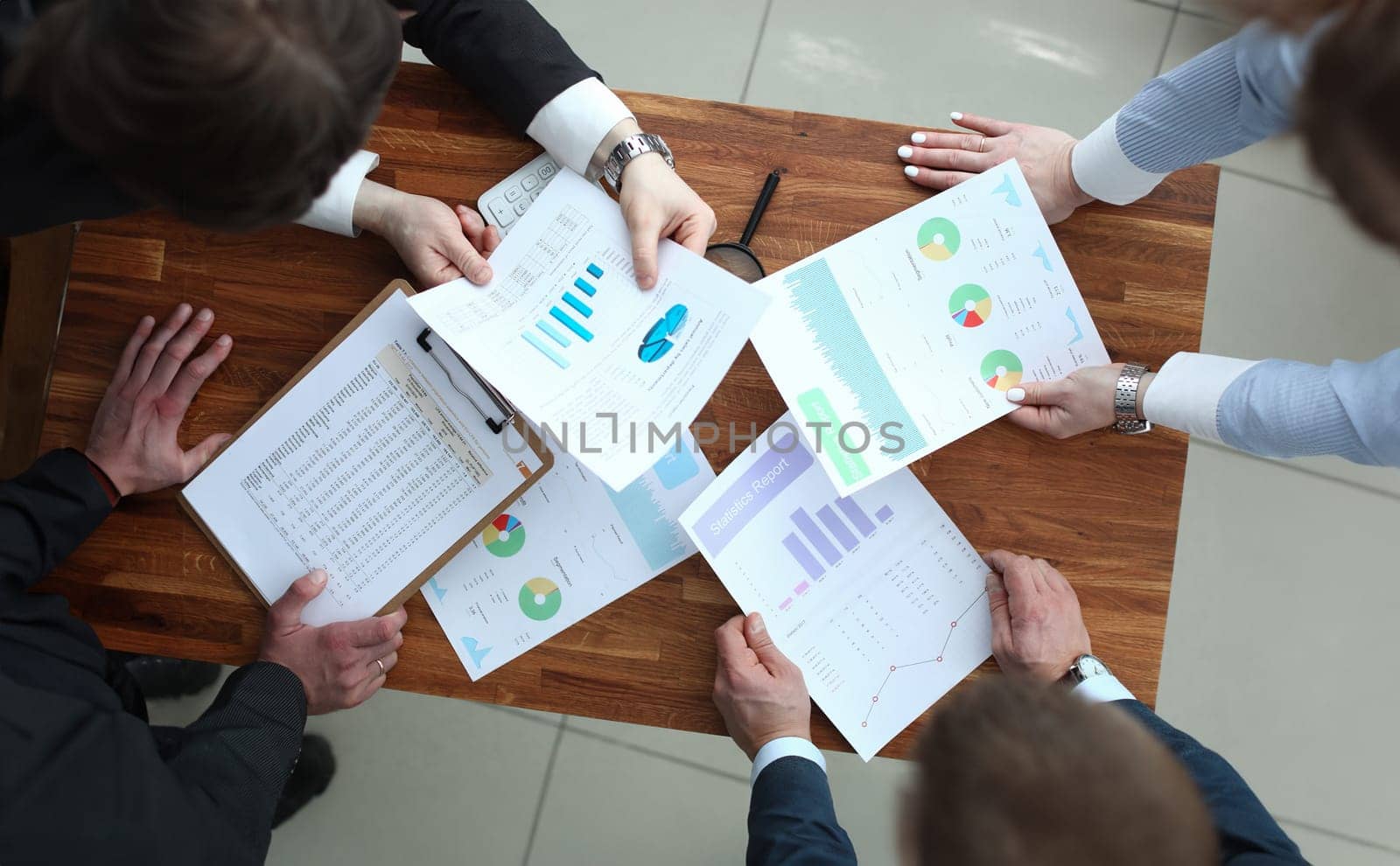 Group of business people discussing charts on paper top view by kuprevich