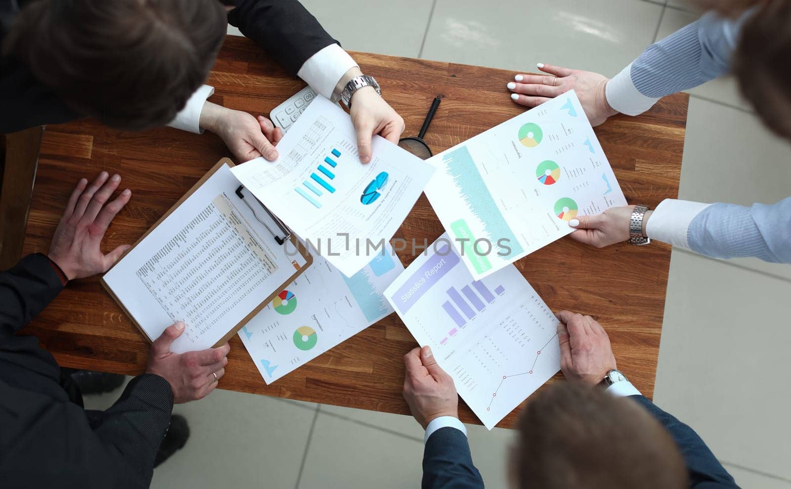 Group of business people discussing charts on paper top view. Business education concept