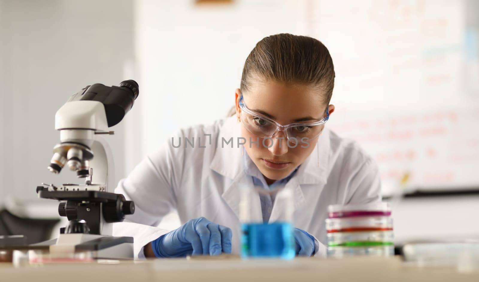 Woman chemist conducting scientific experiments in laboratory. Chemical education concept