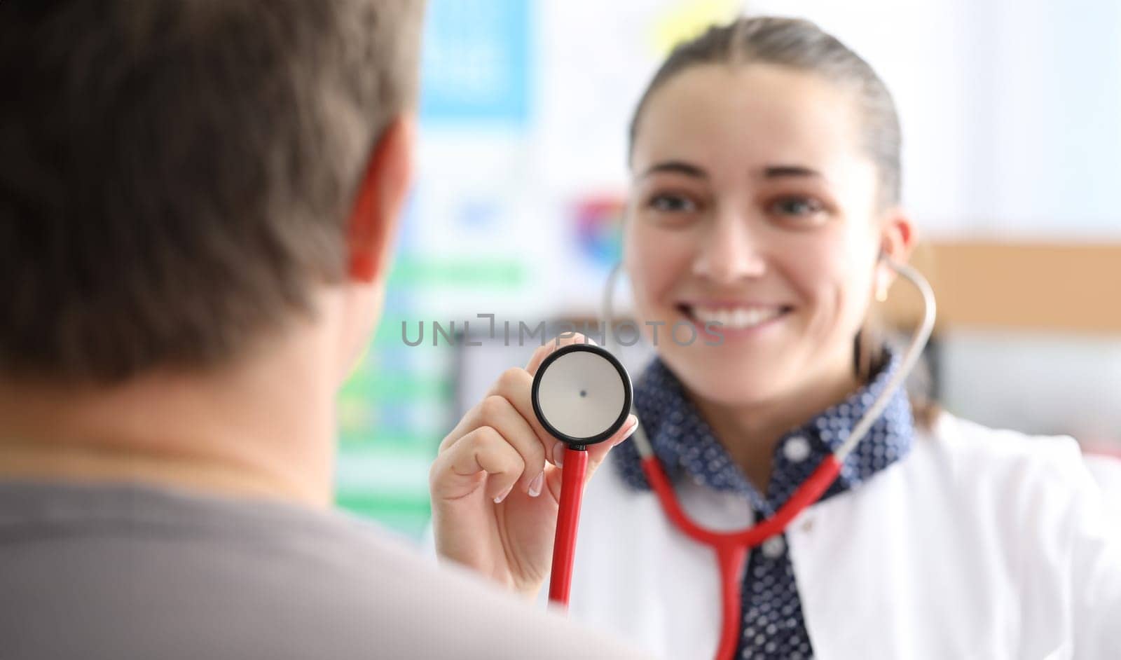 Woman doctor holding stethoscope in front of patient closeup by kuprevich