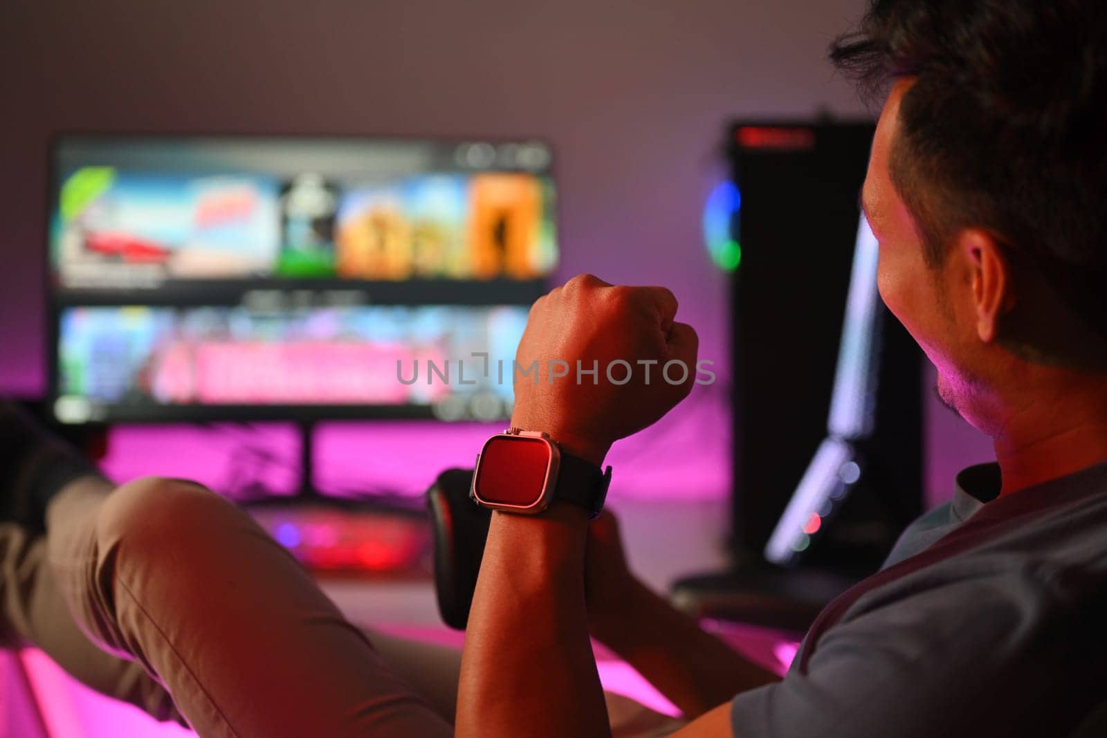 Happy gamer celebrating victory while playing online video game at home