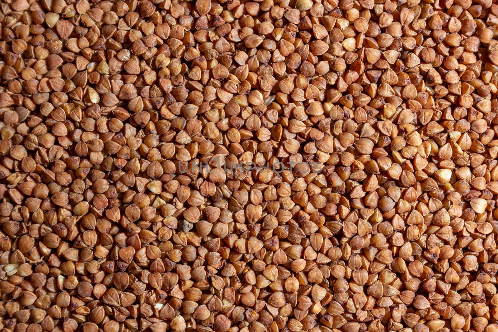 Dry Uncooked Brown Buckwheat Groats Background by InfinitumProdux