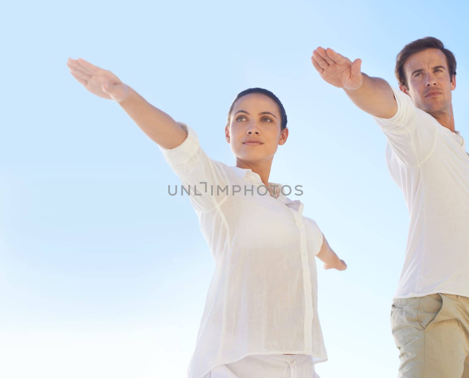 Woman, sky and couple of friends in yoga exercise, fresh air and outdoor wellness for morning fitness. Sunshine, marriage partner and people doing pilates, workout or training routine.