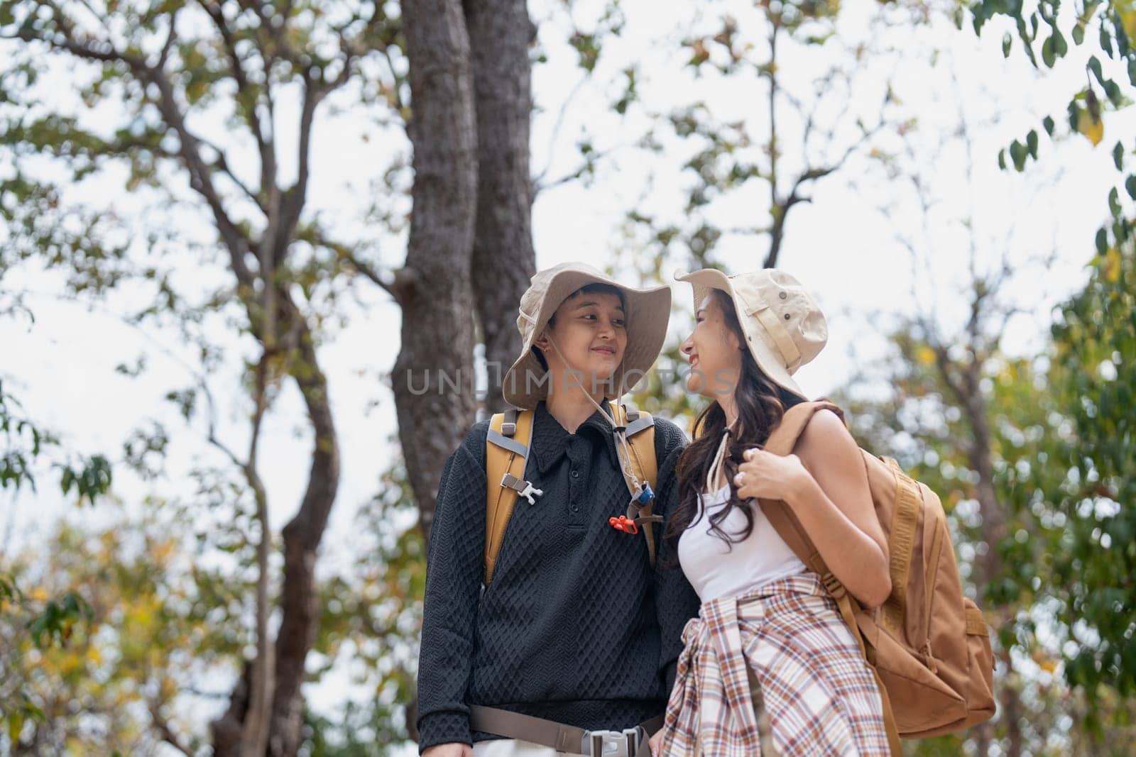 Lovely couple lesbian woman with backpack hiking in nature. Loving LGBT romantic moment in mountains.