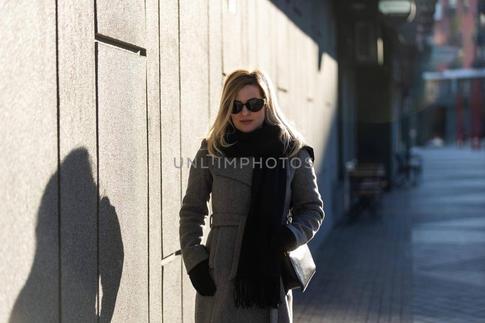 A young girl blonde walks through the city.