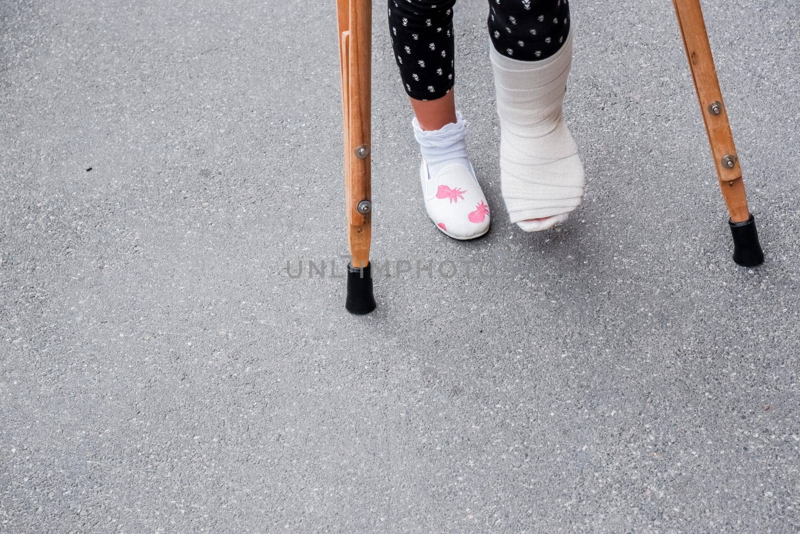 Little girl with crutches at the stair. Back to school