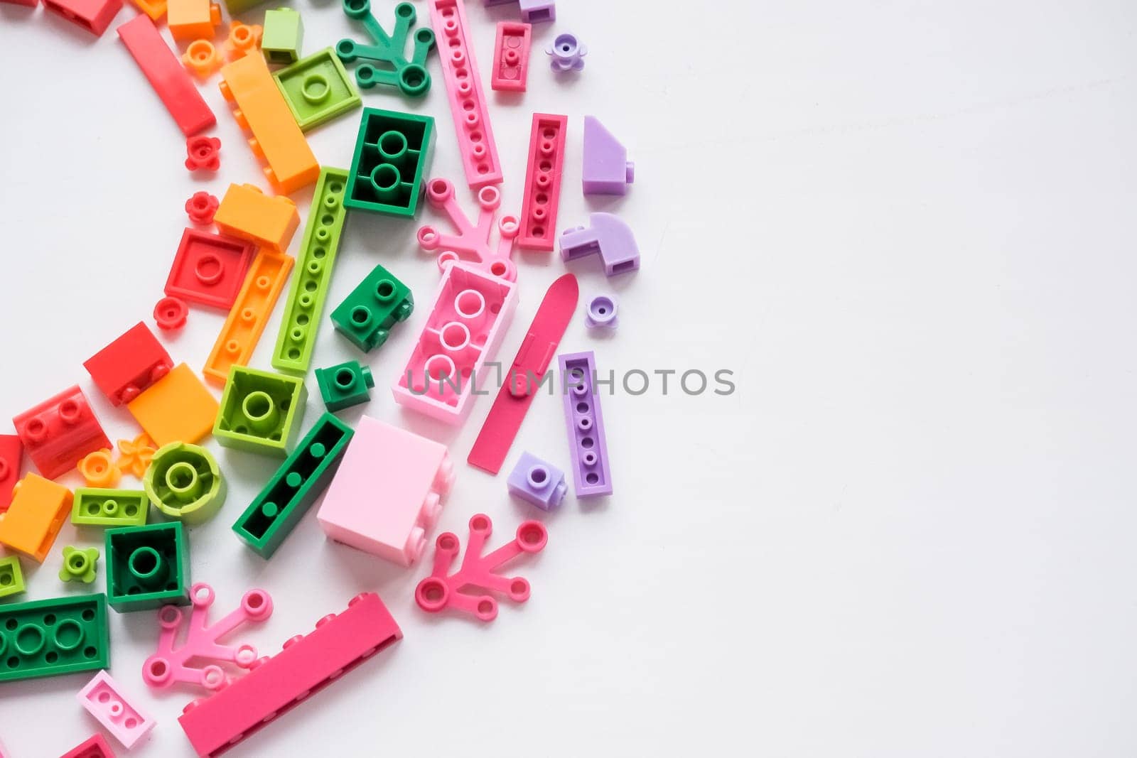 Toys background. Colorful wooden cubes and plastic construction blocks frame on white background.