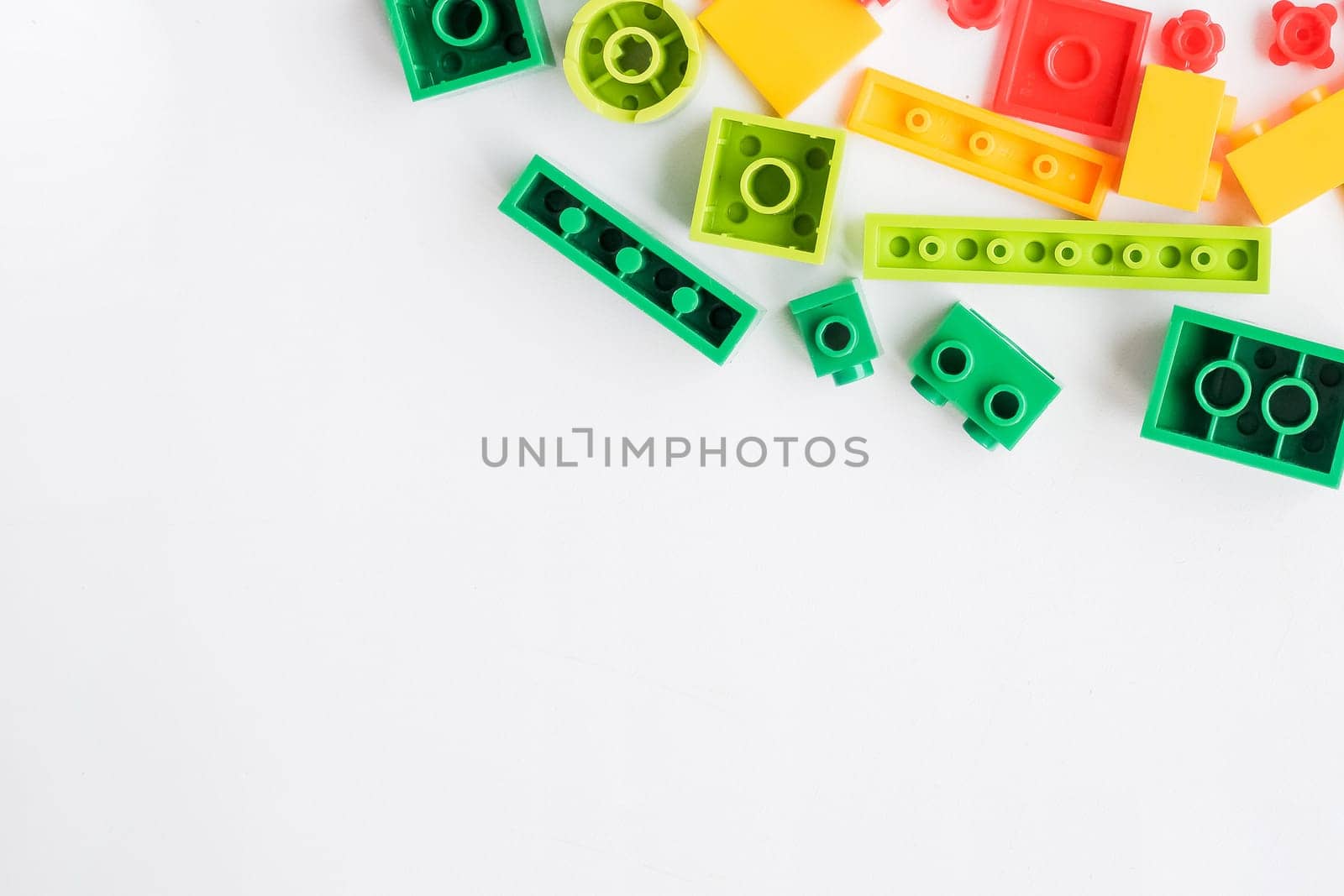 Flat lay colorful plastic building blocks on pastel blue background. Baby educational toys concept.