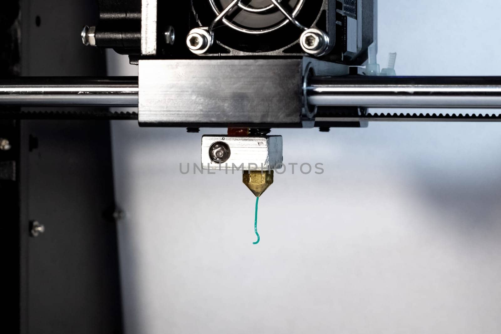 3D printer nozzle and green plastic close up