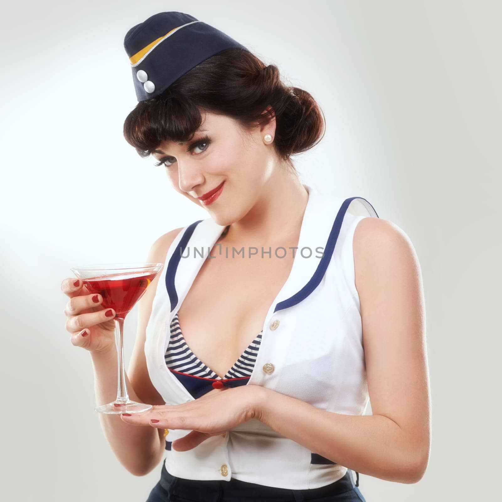 Portrait, stewardess and woman with alcohol to drink in studio isolated on white background. Face, martini cocktail glass and air hostess with service, travel and vintage pin up girl model on journey.