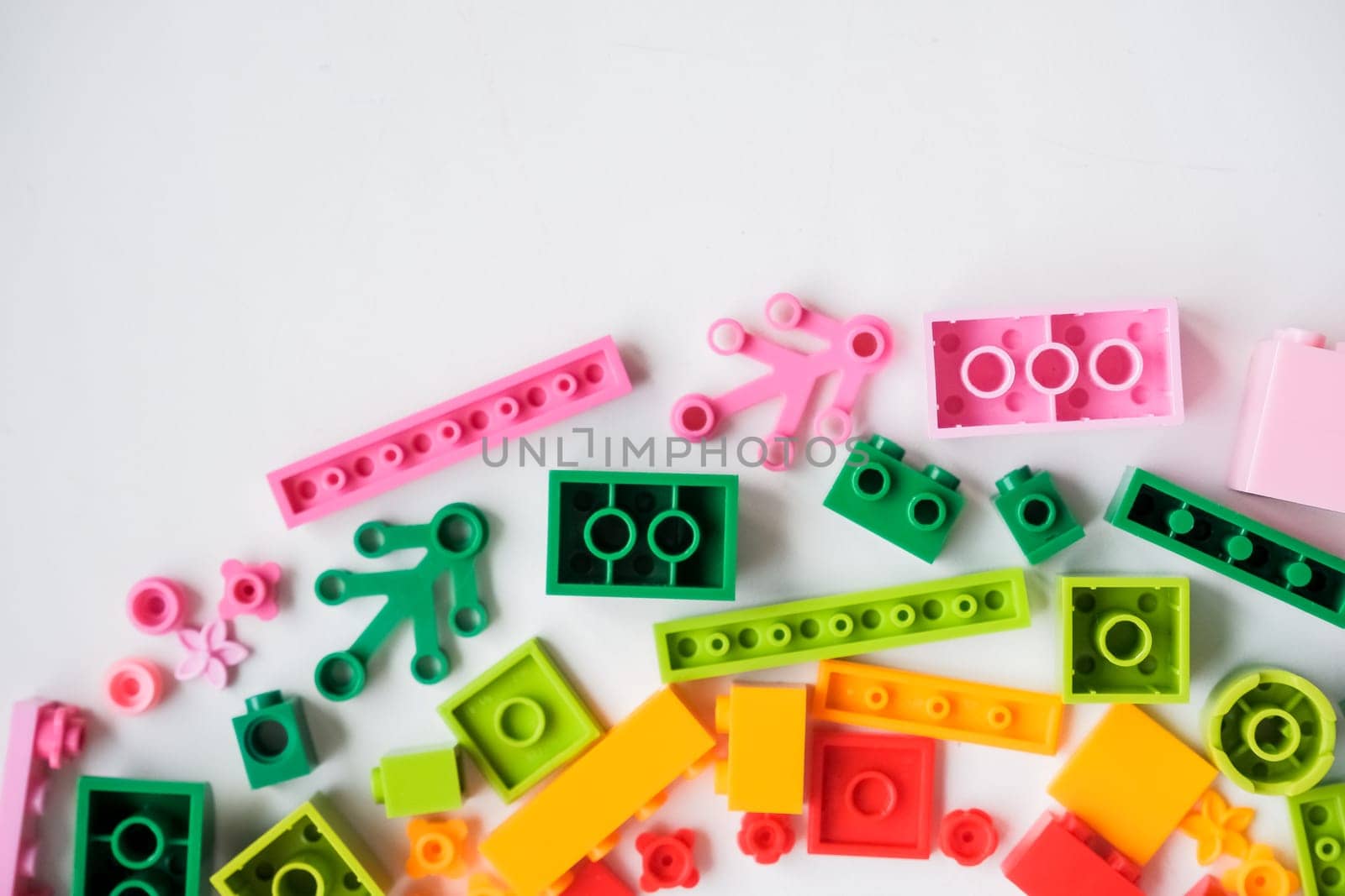 Lot of colorful rainbow toy bricks on white background. Educational toy for children. Top view with copy space. bright plastic building blocks.create and learn colors. Educational toys for creative children. by YuliaYaspe1979