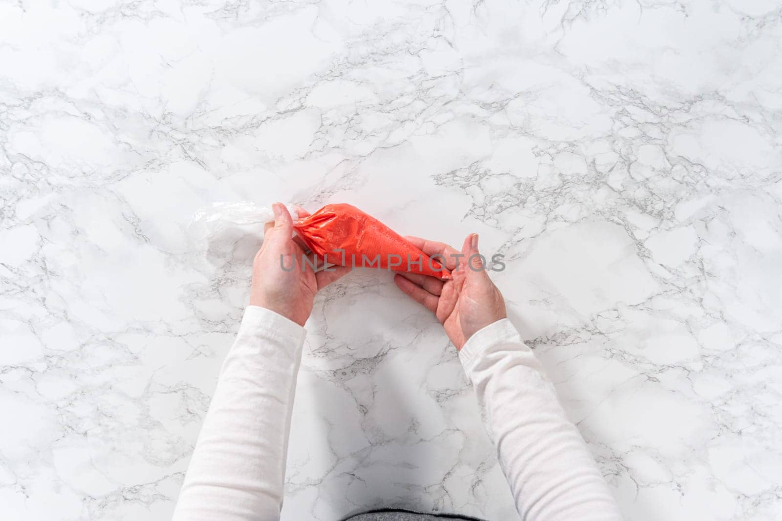 Flat lay. Homemade royal icing in piping bags ready to decorate sugar cookies on the kitchen counter.