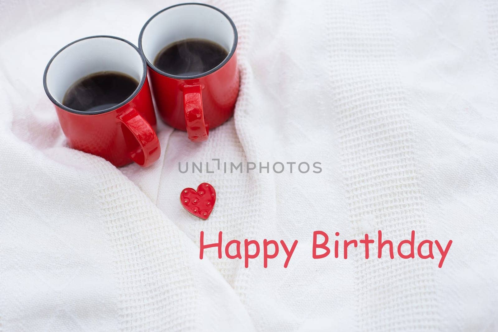 Romantic still life, two red cups of coffee on a white plaid. Happy birthday lettering, holiday card. by sfinks