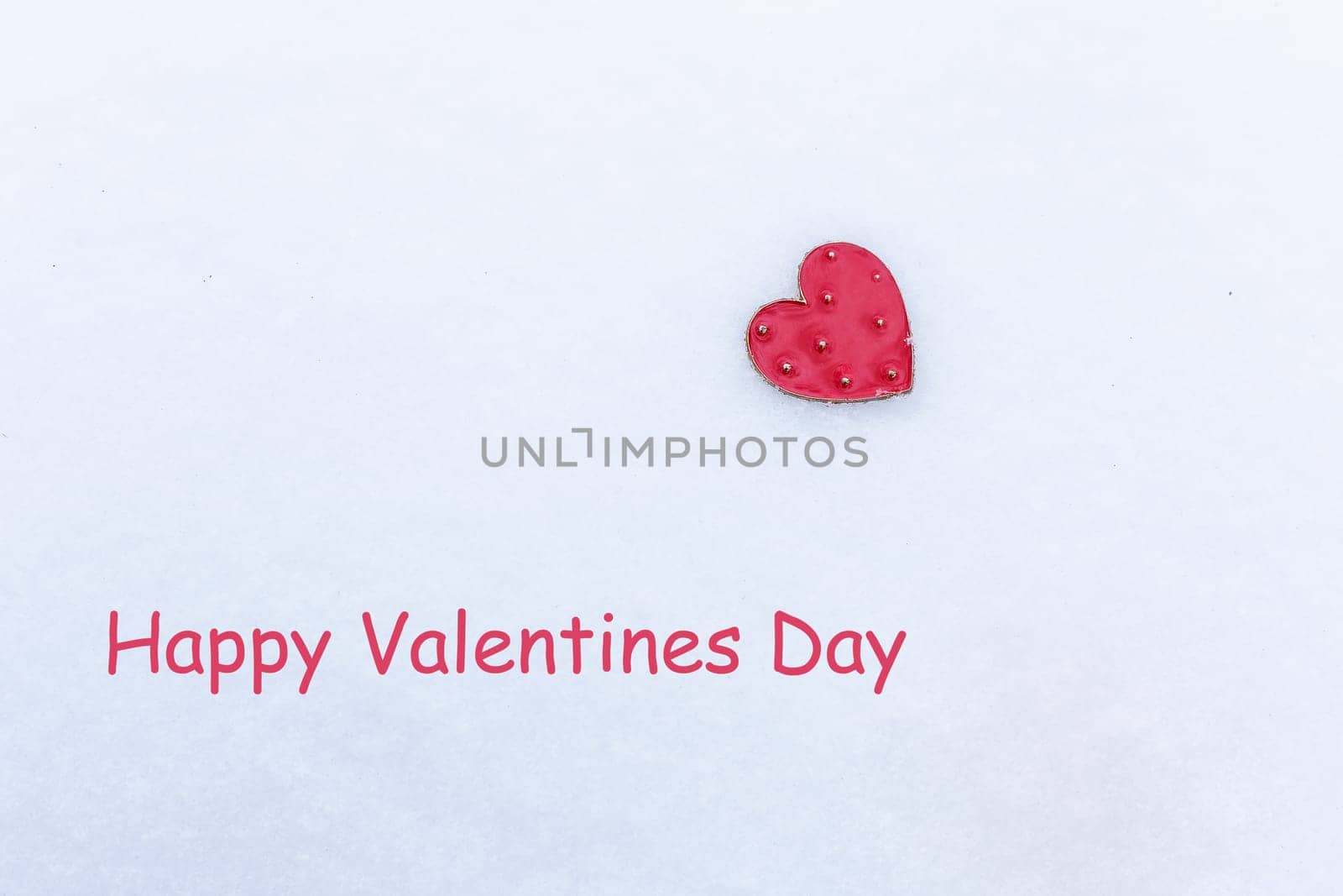 Red heart lies in the snow, holiday concept, lettering Valentine's Day, ready postcard. by sfinks