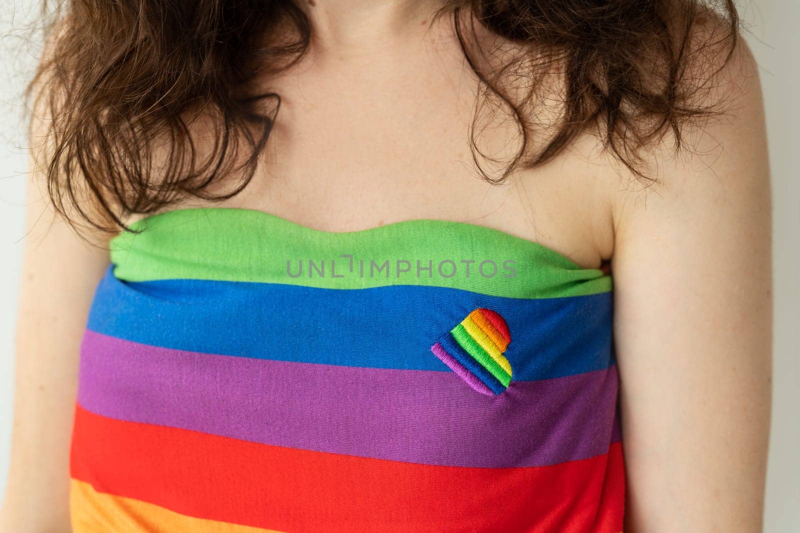 Close-up of a girl wearing a rainbow tube top with a small rainbow ribbon attached to the fabric. LGBT support. by sfinks