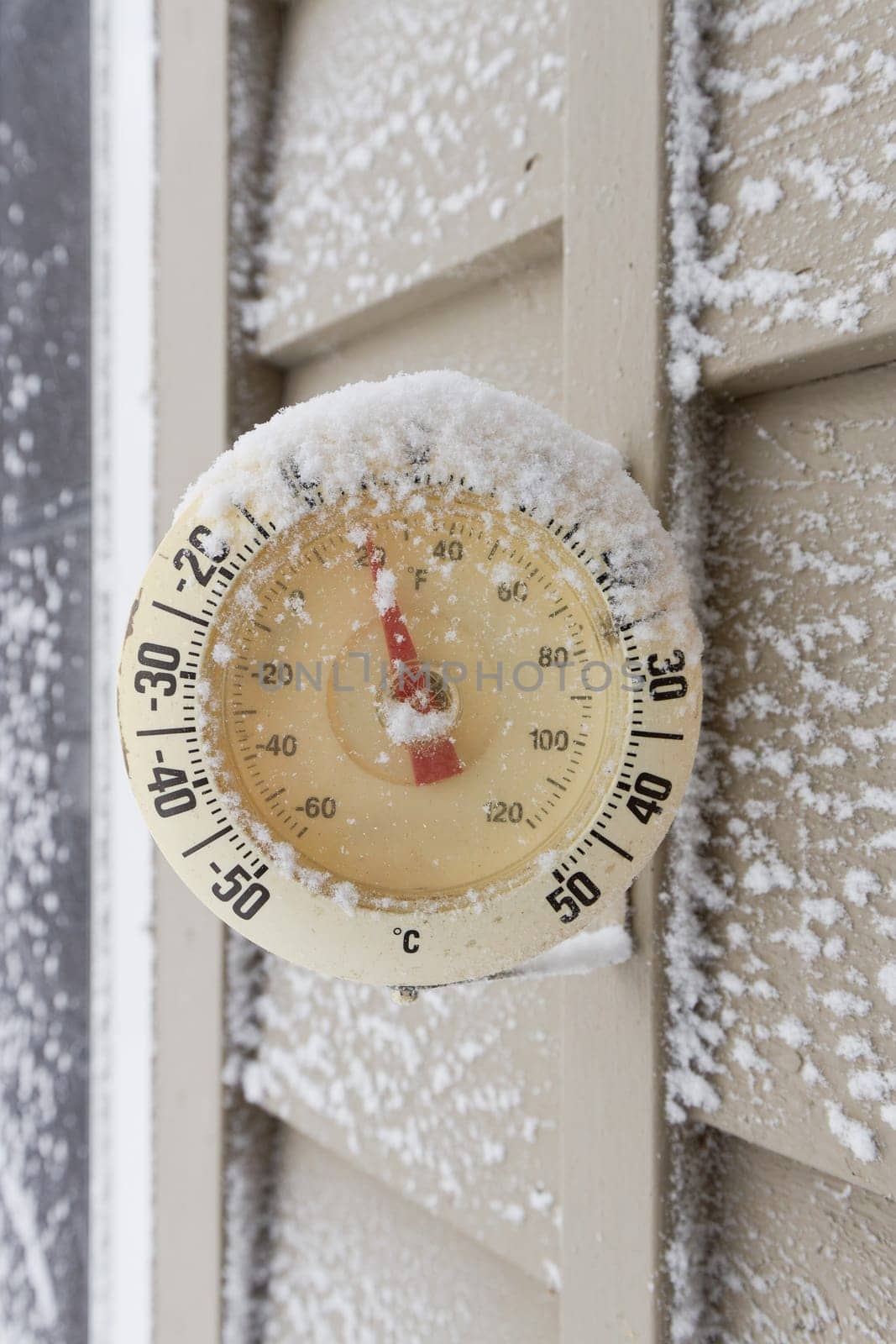 Snow Capped Thermometer Mounted on Wooden Siding of House Showing Freezing Temperatures by markvandam
