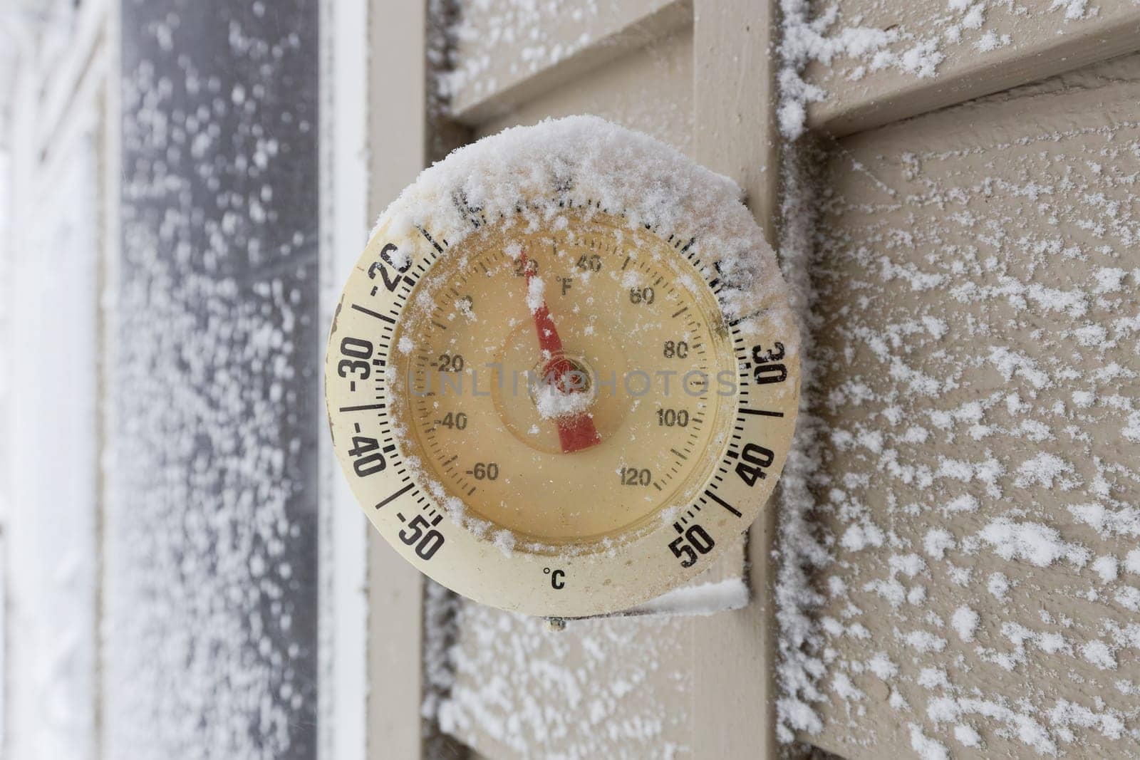 Snow Capped Thermometer Mounted on Wooden Siding of House Showing Freezing Temperatures by markvandam