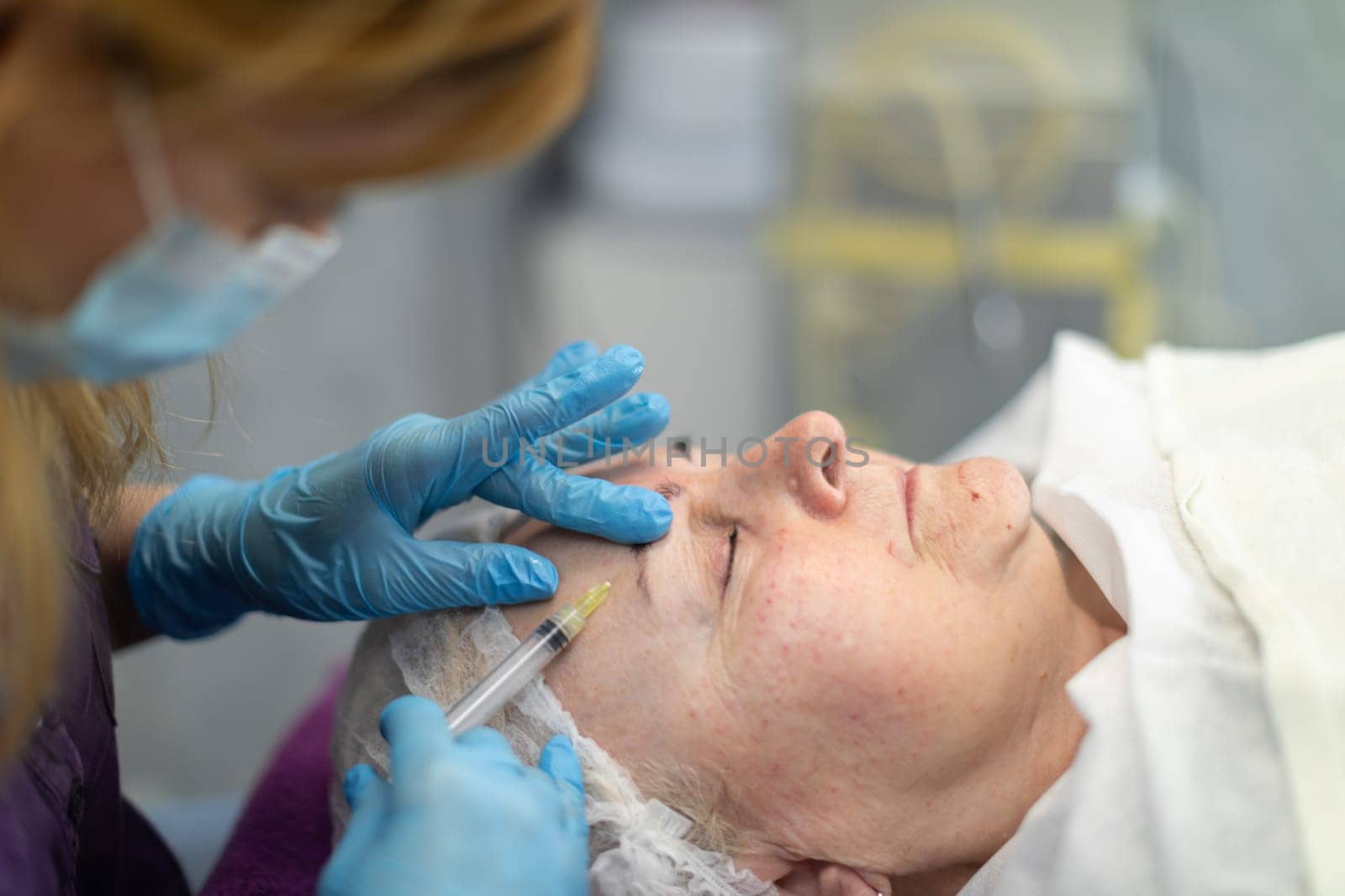 A cosmetologist at a beauty salon performs precise injections. by fotodrobik