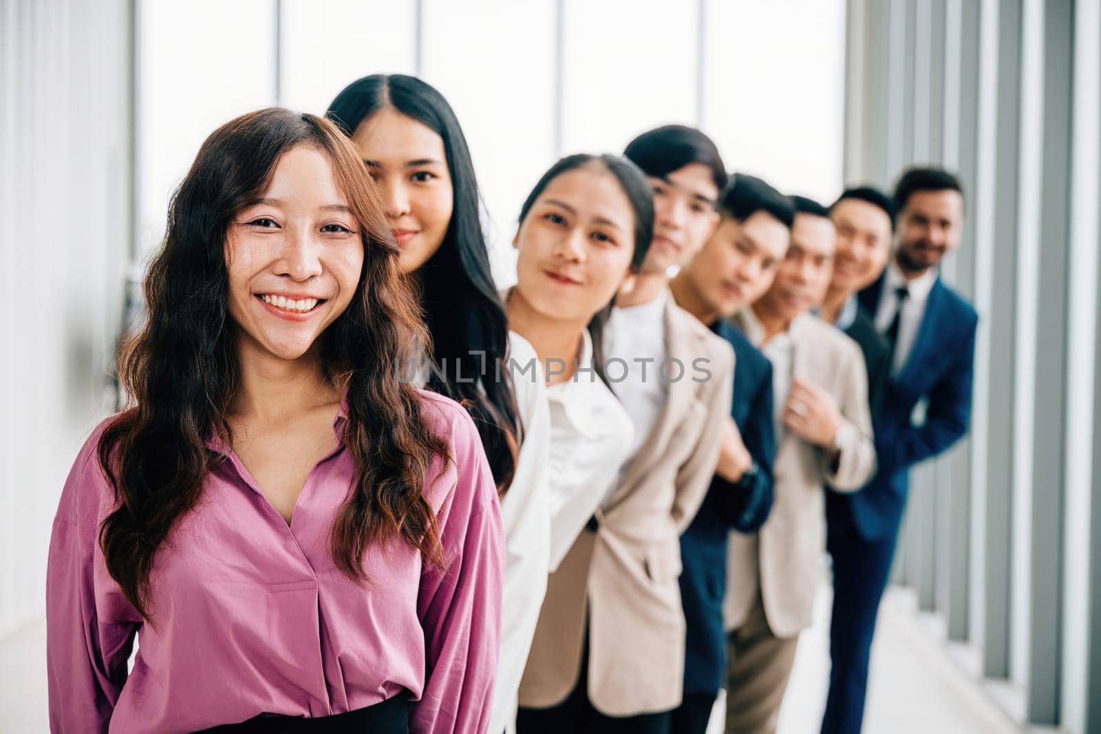 A vibrant group portrait of young business professionals in the office, crossing their arms with pride. This diverse and confident team embodies the values of teamwork and success. by Sorapop