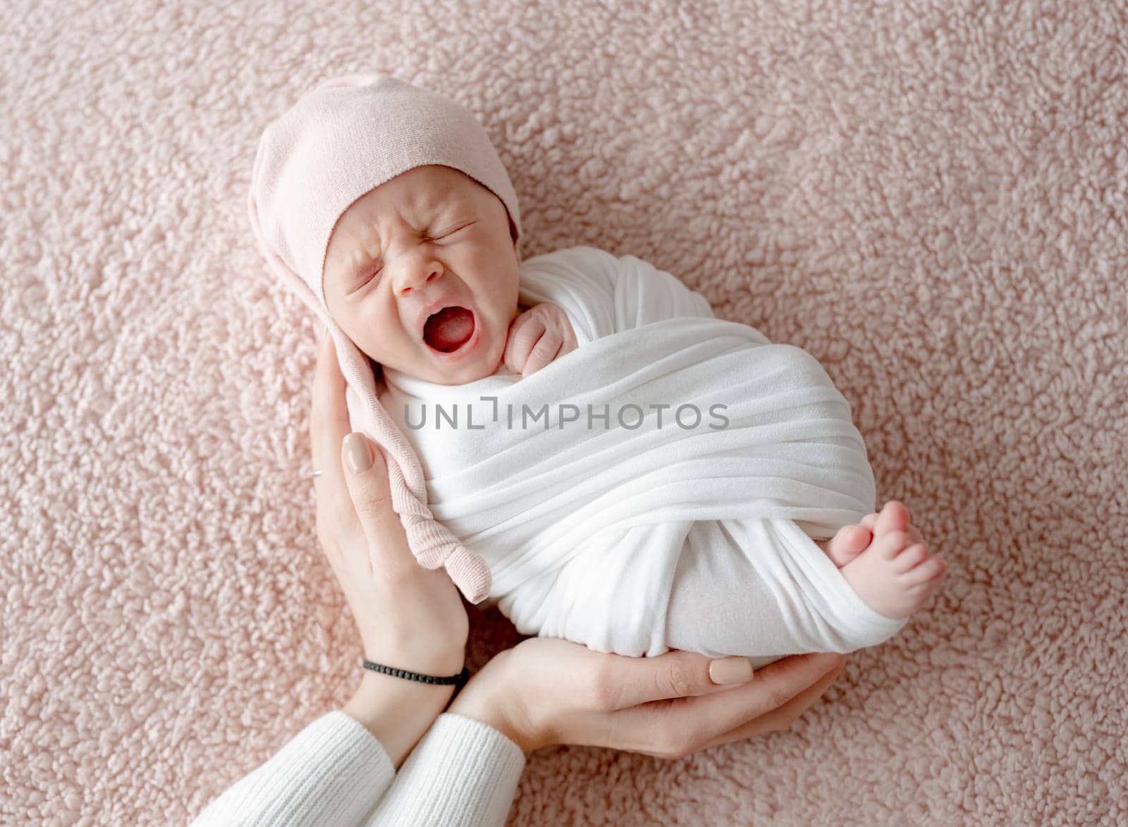 Newborn Baby Yawns In Sleep While Mother'S Hands Gently Hold Him by tan4ikk1