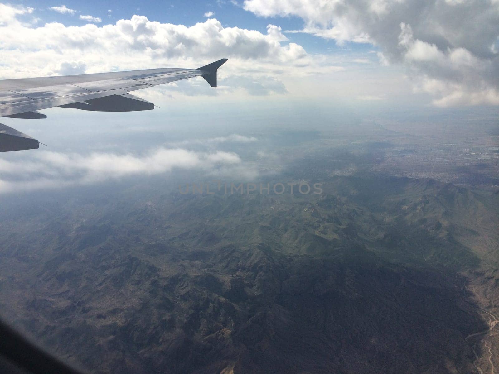 View from Airplane Window of Mountains and Clouds. High quality photo