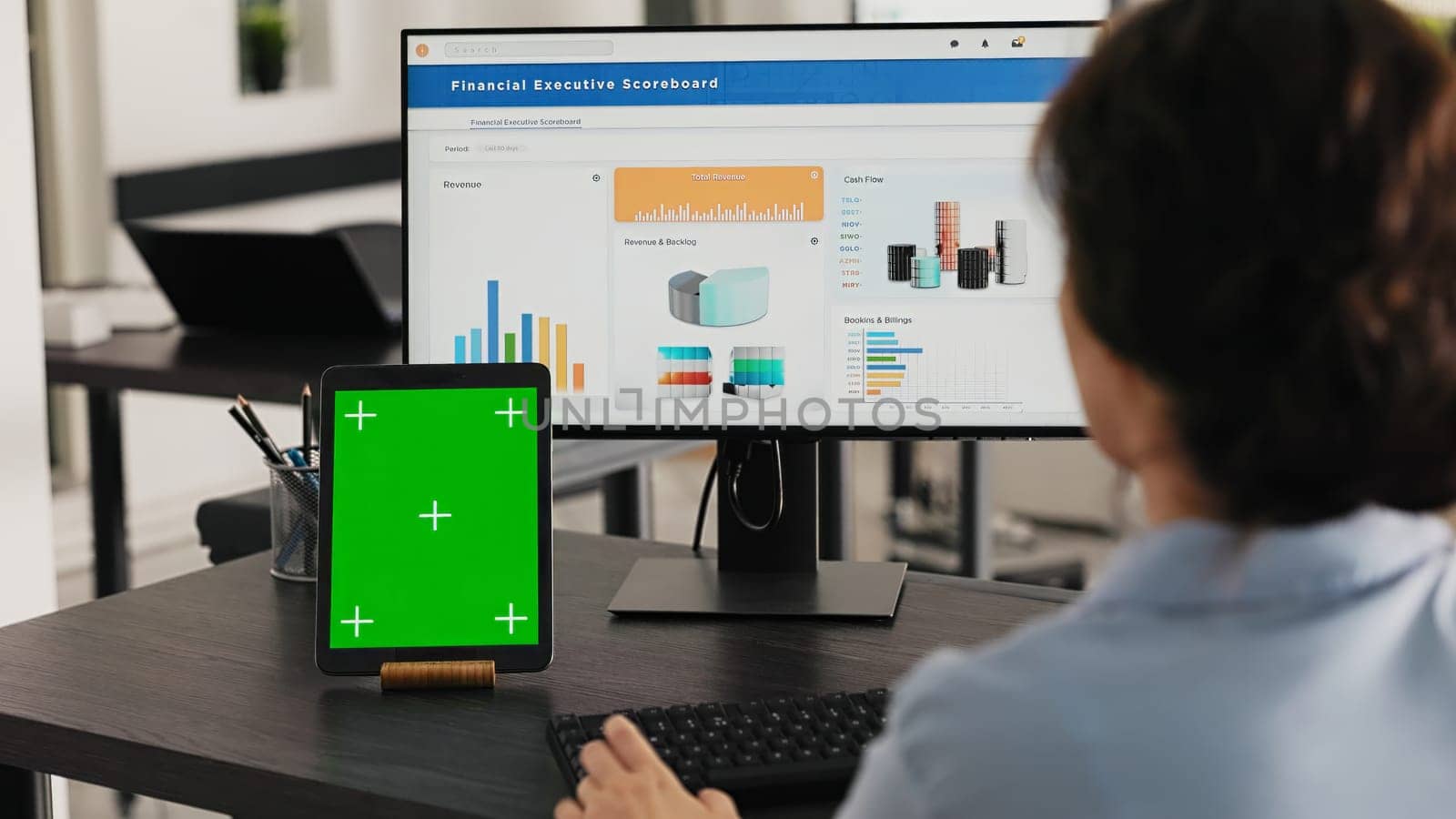 Manager watches tablet with greenscreen while she solves business operations in office, looking at device running blank mockup display. Specialist looks at chromakey software. Handheld shot.