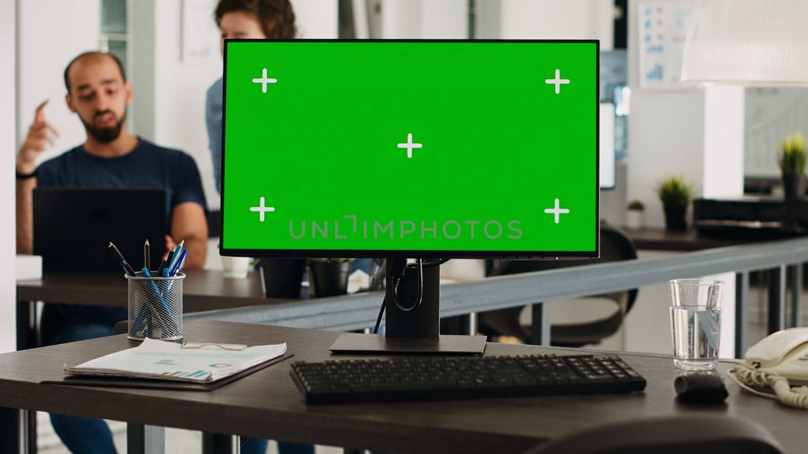 Computer desktop with greenscreen on empty office workstation, mockup screen showing copyspace chromakey in small business agency workplace. Isolated display on monitor, coworking space.