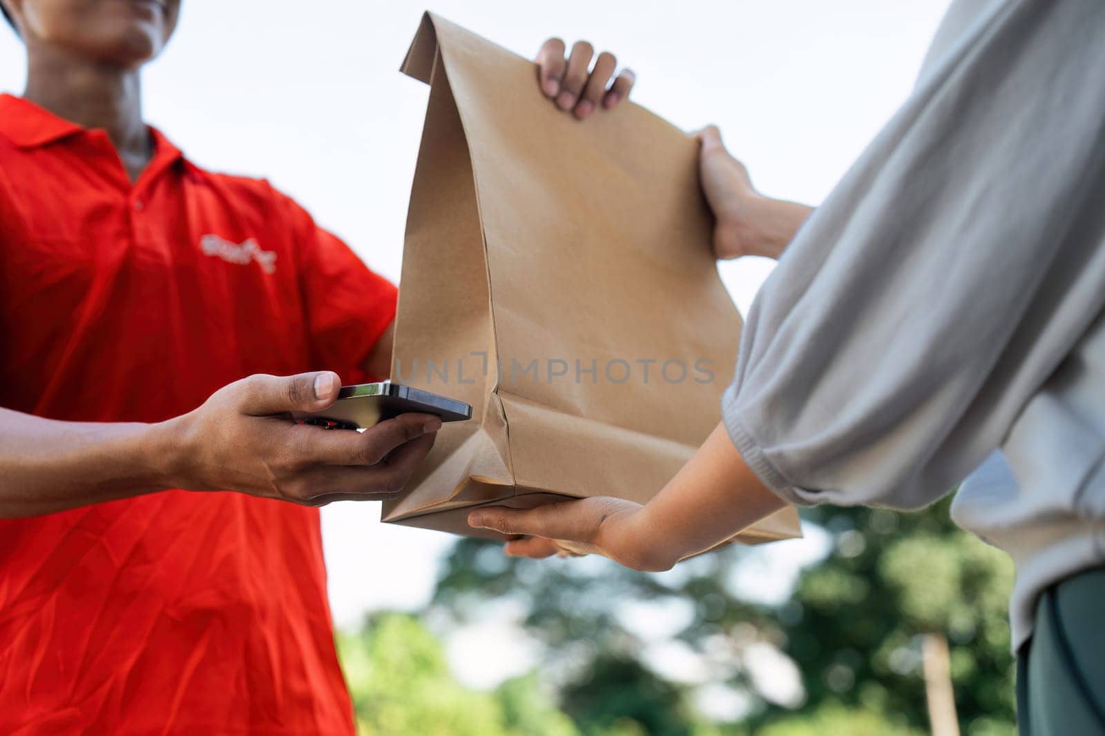 Asian young delivery man delivering package to female customer at home.