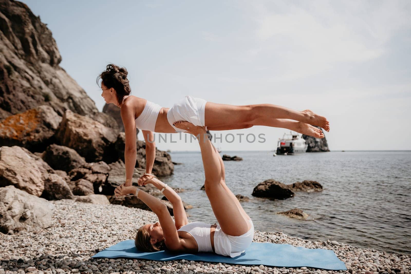 Woman sea yoga. Back view of free calm happy satisfied woman with long hair standing on top rock with yoga position against of sky by the sea. Healthy lifestyle outdoors in nature, fitness concept.