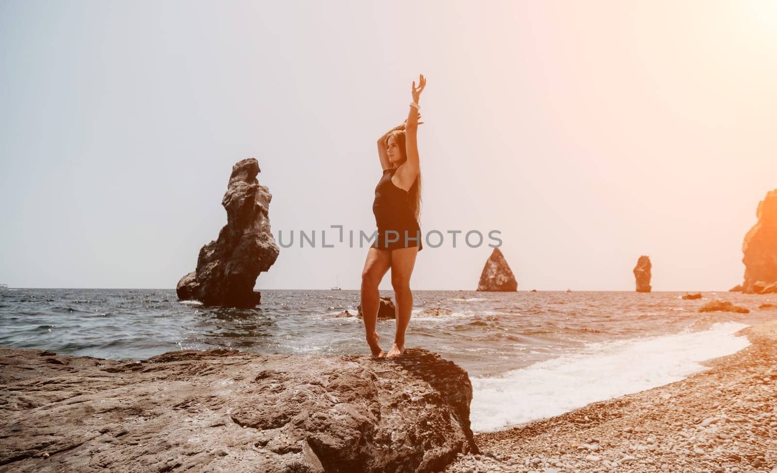 Woman summer travel sea. Happy tourist in hat enjoy taking picture outdoors for memories. Woman traveler posing on the beach at sea surrounded by volcanic mountains, sharing travel adventure journey by panophotograph