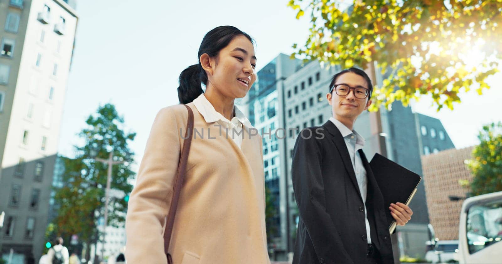 Walking, conversation and business people in the city talking for communication or bonding. Smile, discussion and professional Asian colleagues speaking and laughing together commuting in town