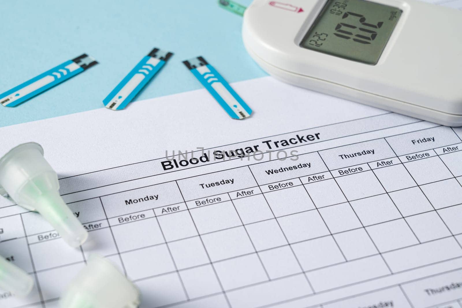 Top view of glucometer, lancet pen, strips and blood sugar tracker on blue background. diabetes test kit by Sonat