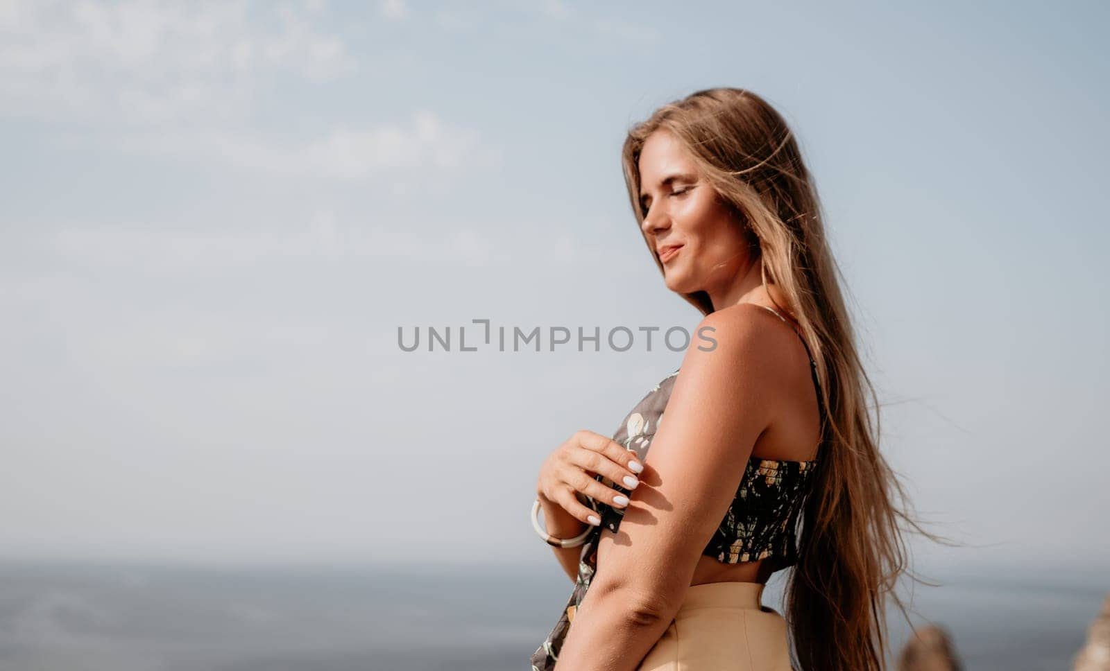 Woman travel sea. Happy tourist taking picture outdoors for memories. Woman traveler looks at the edge of the cliff on the sea bay of mountains, sharing travel adventure journey by panophotograph