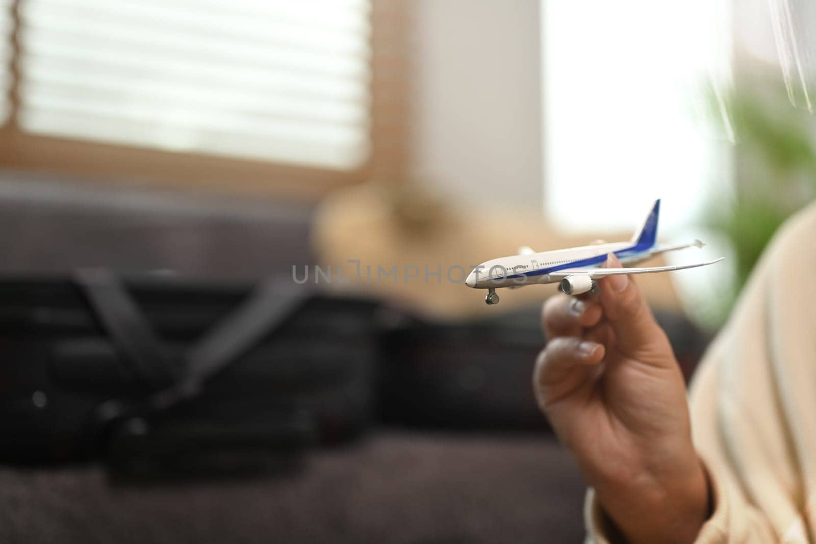 Woman hand holding airplane model. Traveling, vacation and transportation concept.