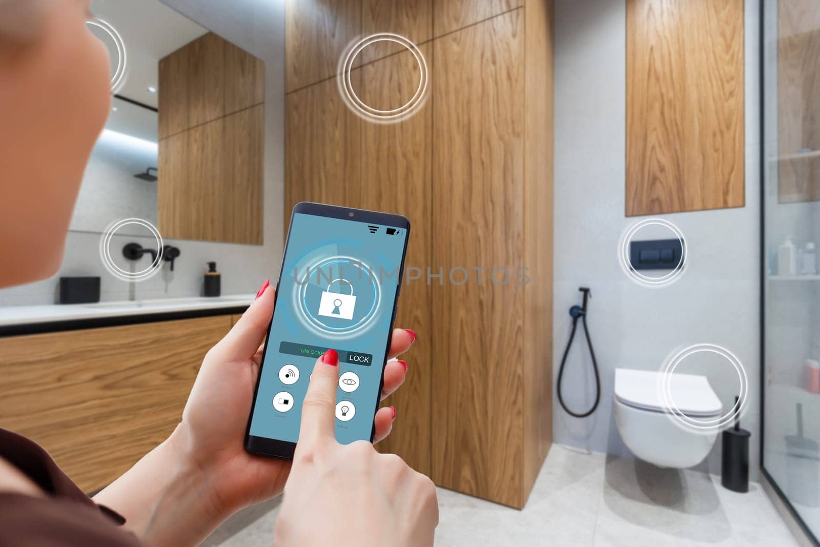 Close up smartphone in female hand with smart home system app interface on cellphone screen, young woman controlling all house system by phone in modern apartment, internet of things concept