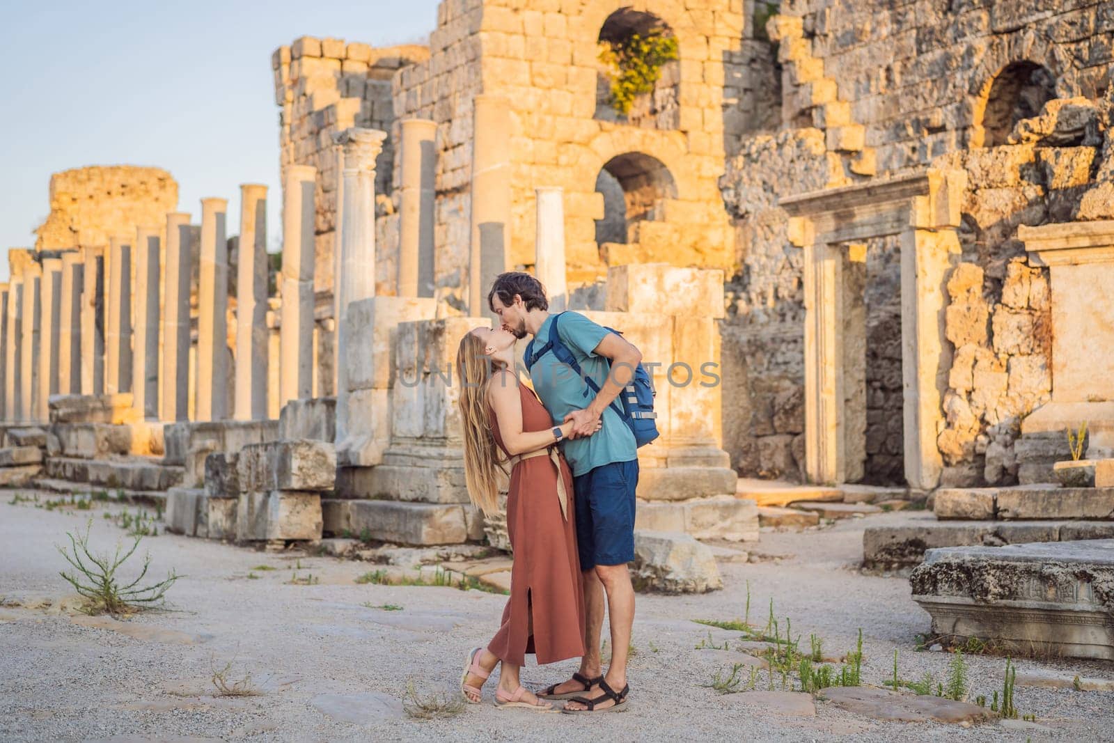 Loving couple of tourists at the ruins of ancient city of Perge near Antalya Turkey. Traveling with kids concept.