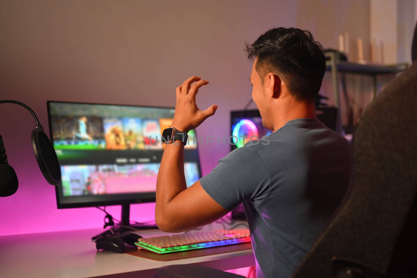 Young gamer playing online video games on computer, upset about the defeat by prathanchorruangsak
