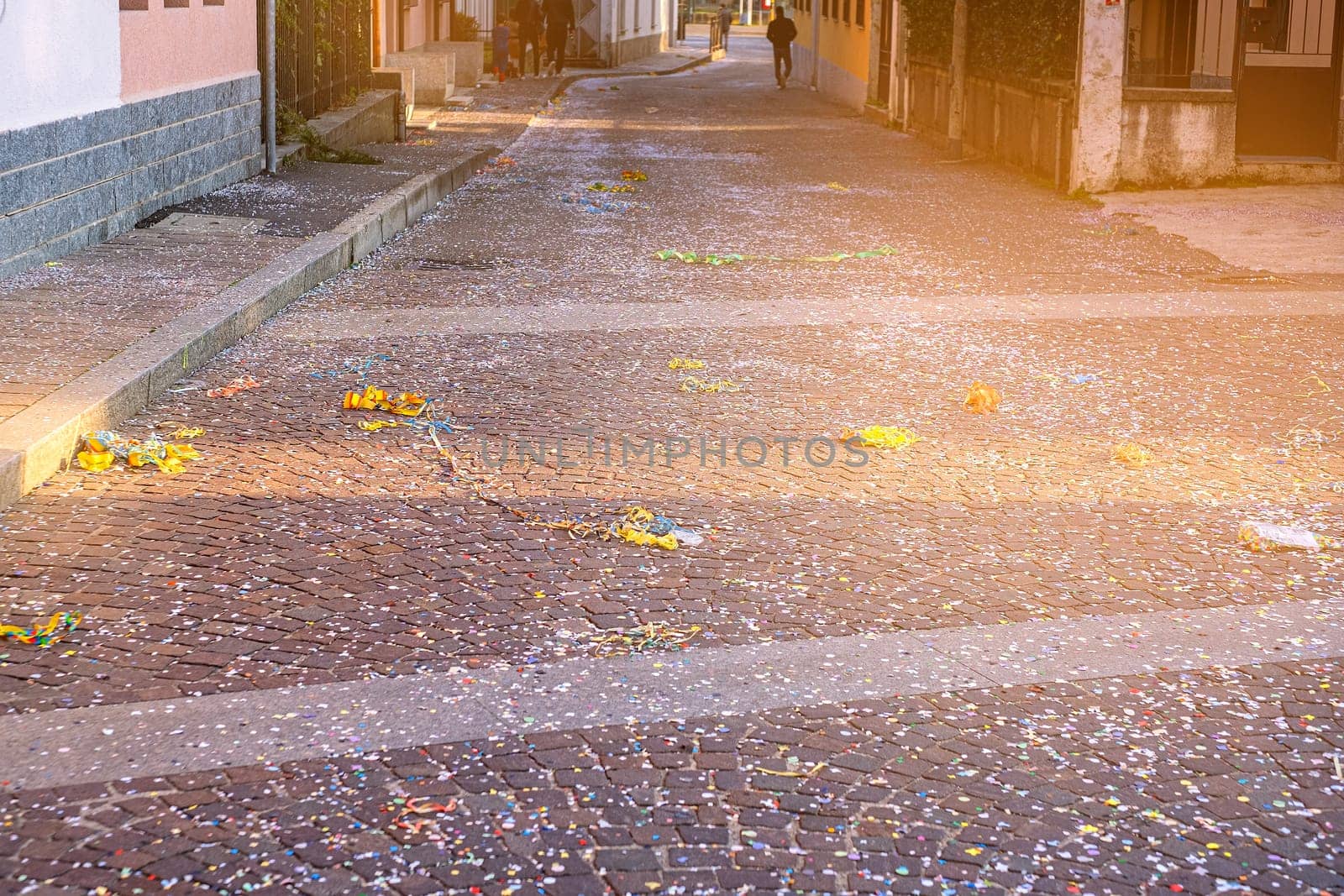 Colorful confetti and streamers at the street after Carnival parade. Italy