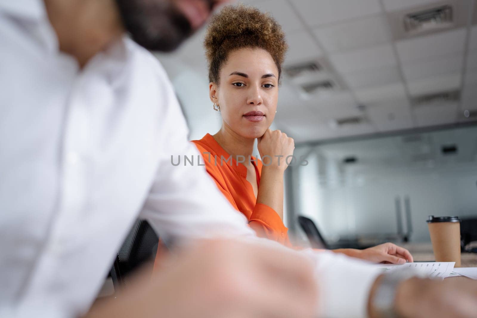 Two young businesspeople smiling while working with wireless technology in a modern workspace.