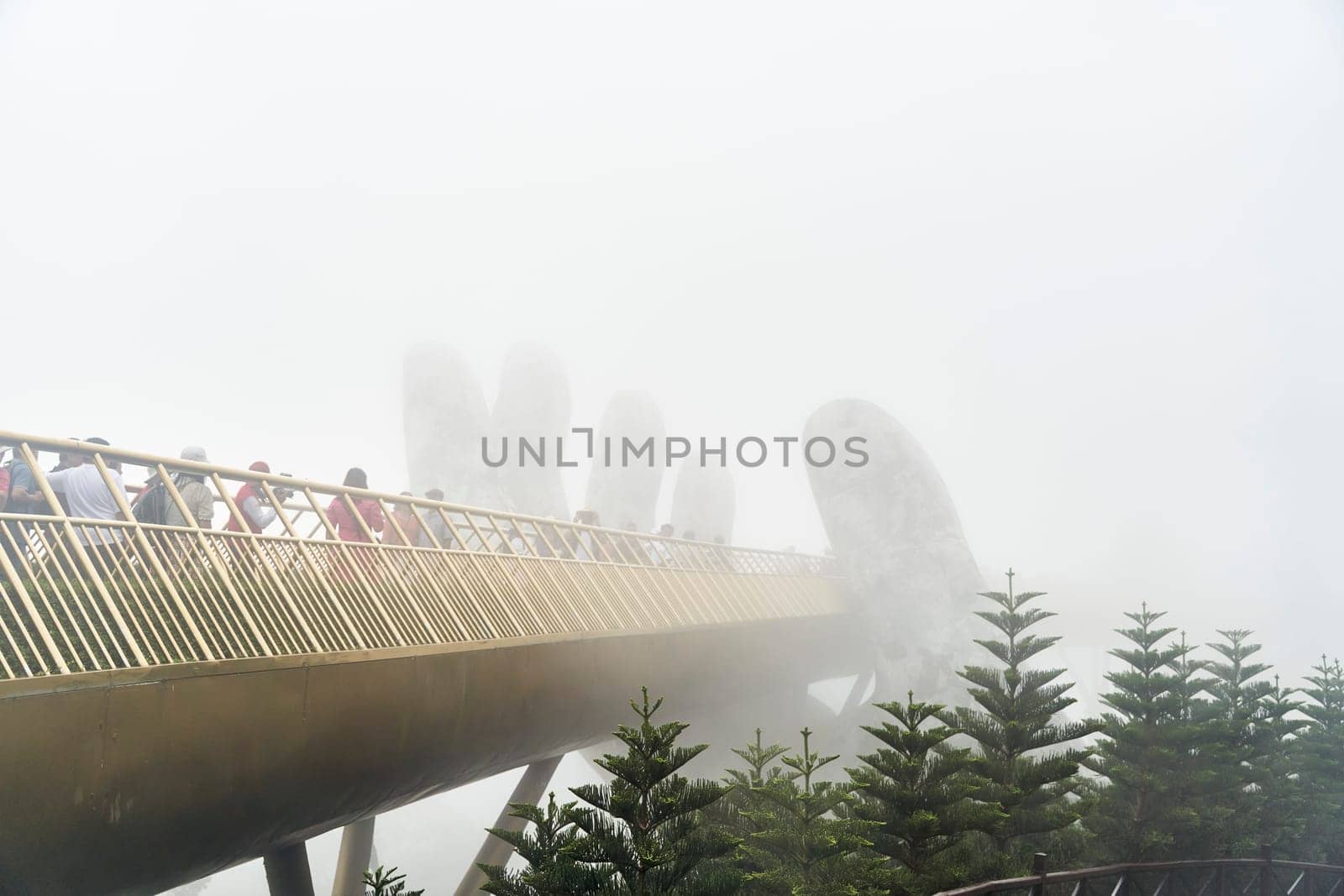 Danang, Vietnam - June 27, 2023: The Golden Bridge is lifted by two giant hands in the tourist resort on Ba Na Hill in Danang, Vietnam.