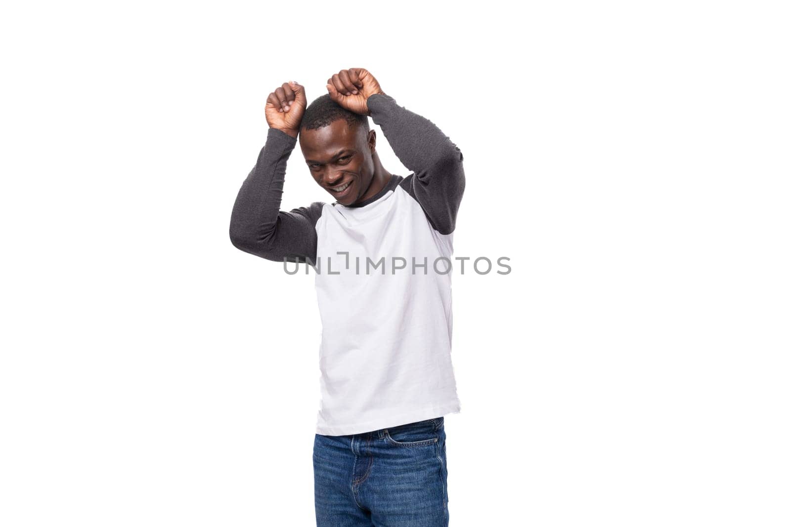 young slender African guy dressed in a black and white sweatshirt posing for the camera.