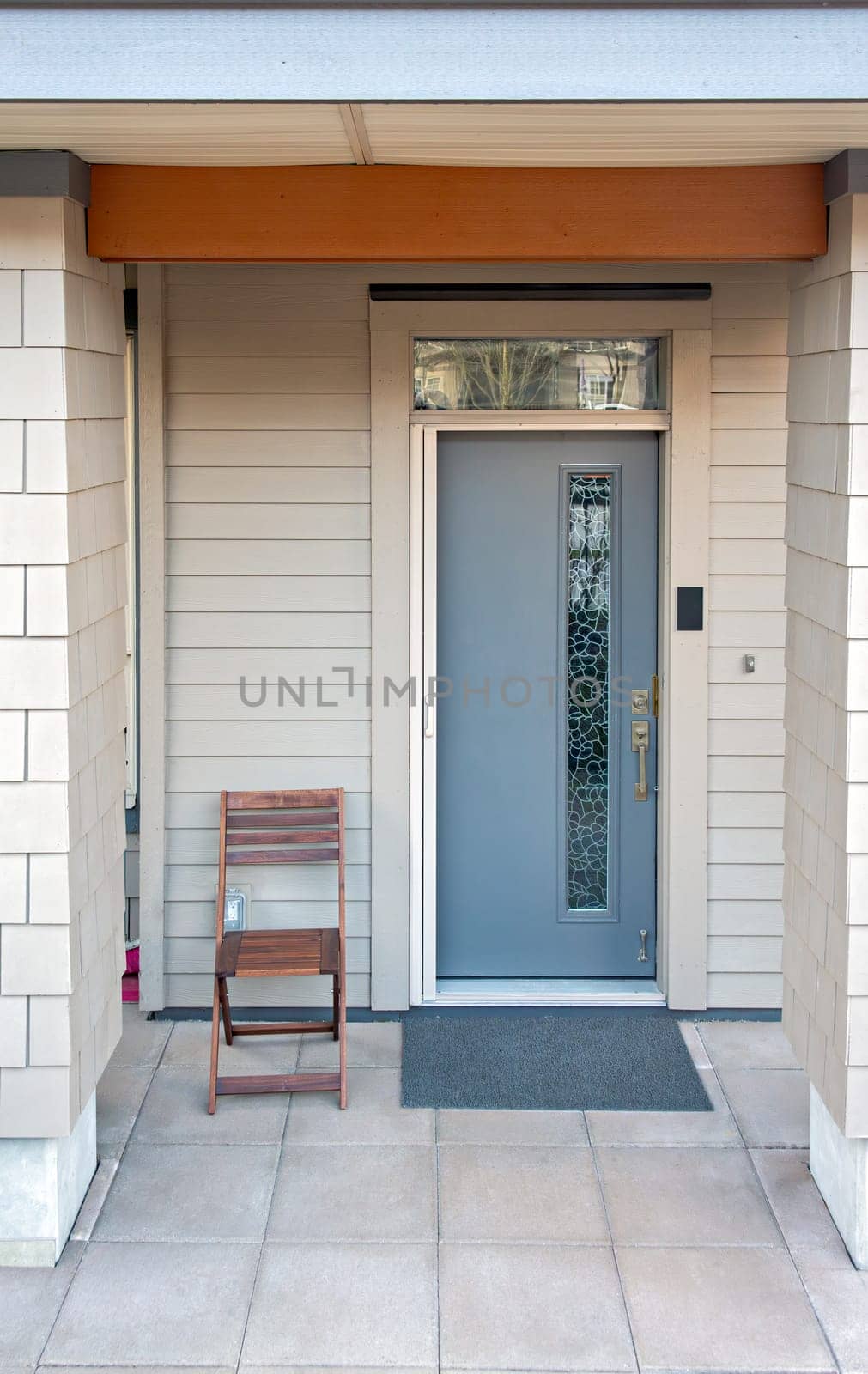 Ground level entrance of residential apartment in low-rise building with wooden seat beside