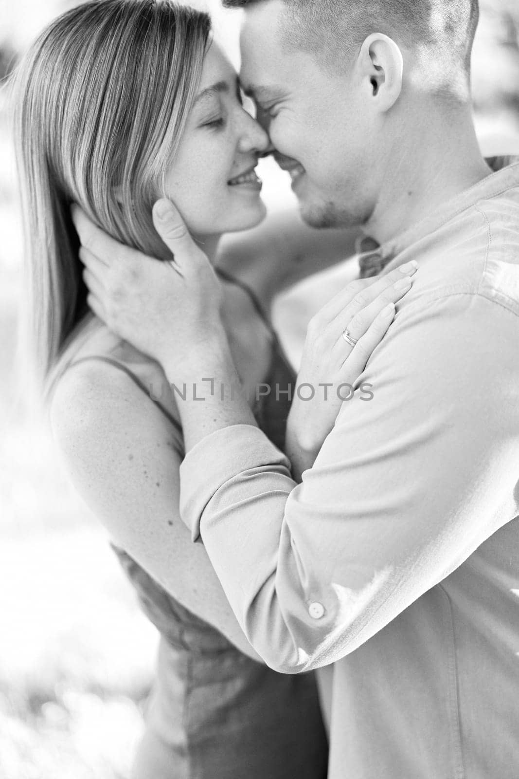 Smiling man and woman hug with their noses touching. Black and white photo. High quality photo