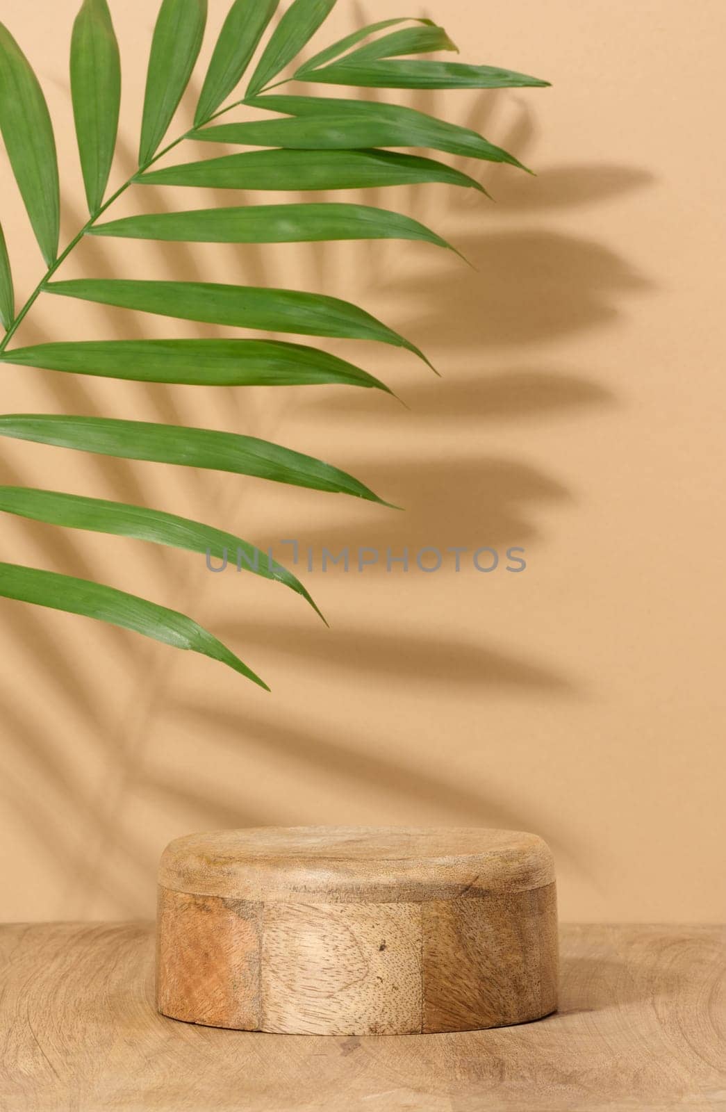 Round brown wooden stand on a beige background, a place to display cosmetics and products by ndanko