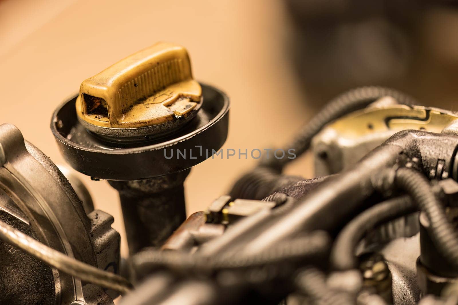 Photo showing a close-up of a dirty oil cap on a car engine, emphasizing the need for maintenance.