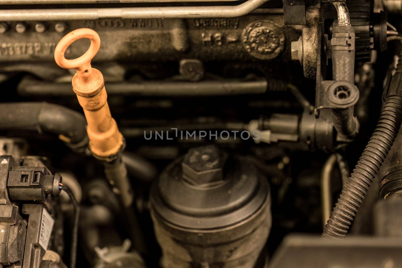 Photo of an oil dipstick in a car engine, symbolizing the crucial need for regular engine maintenance.