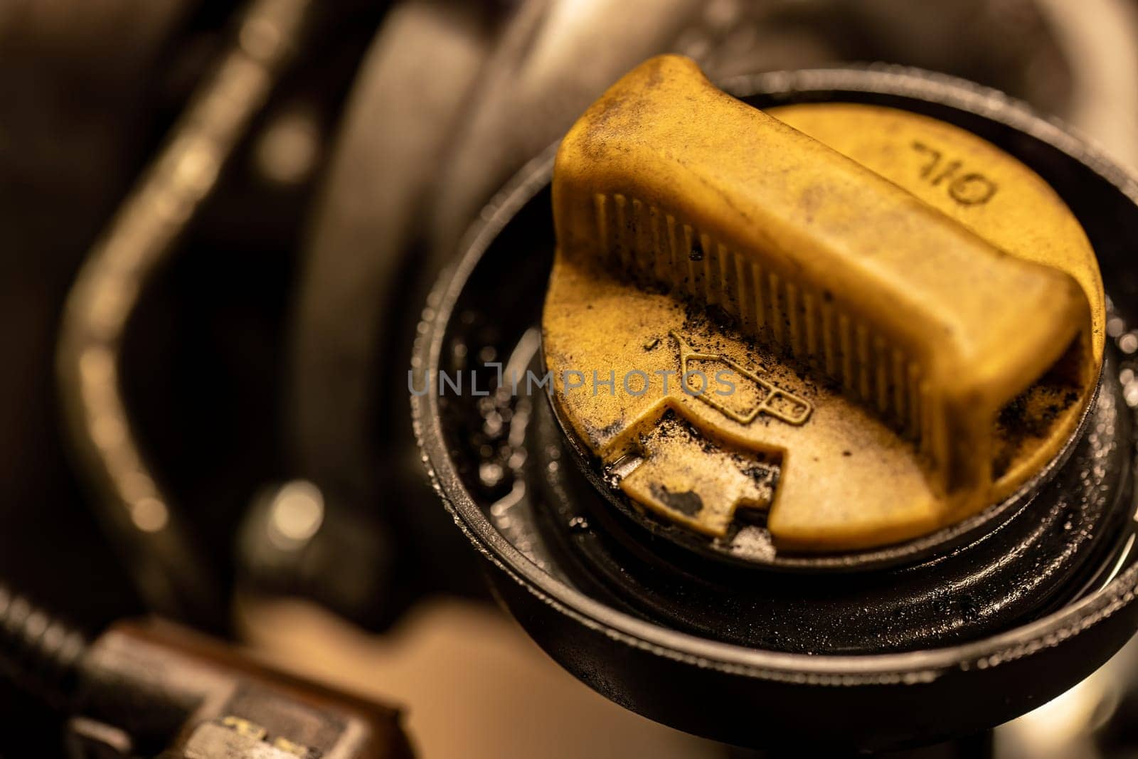 Photo shows a dirty oil cap on a car engine, symbolizing the urgent need for vehicle maintenance.